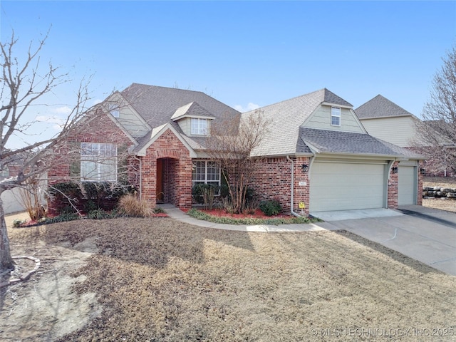 view of front facade featuring an attached garage, a shingled roof, concrete driveway, and brick siding