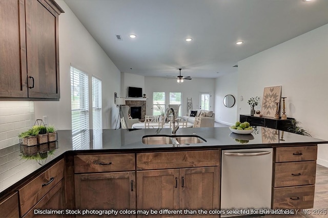 kitchen with sink, hardwood / wood-style flooring, dishwasher, tasteful backsplash, and kitchen peninsula