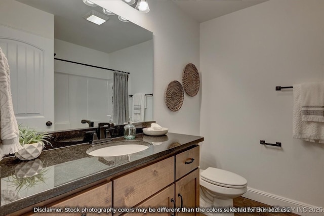 bathroom featuring walk in shower, vanity, toilet, and tile patterned flooring