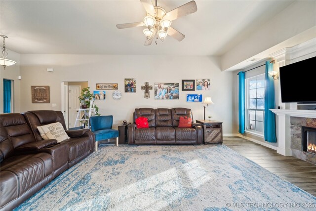 living room featuring ceiling fan, hardwood / wood-style floors, and a fireplace