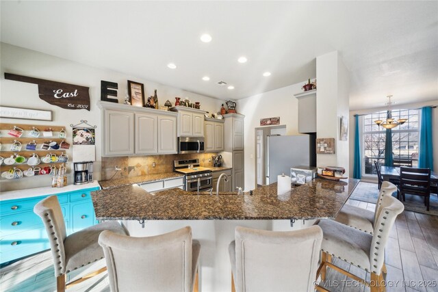 kitchen with tasteful backsplash, stainless steel appliances, a breakfast bar, and light hardwood / wood-style floors