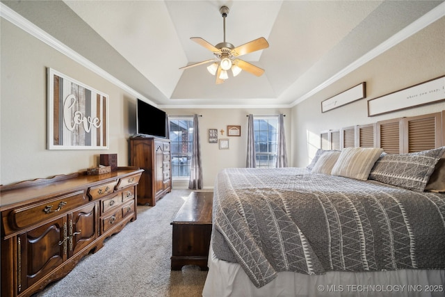 carpeted bedroom featuring ceiling fan and a tray ceiling