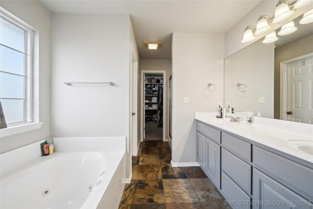 bathroom featuring vanity, plenty of natural light, and a bathtub