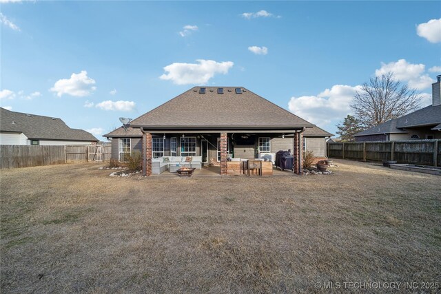 rear view of property featuring a patio and a lawn