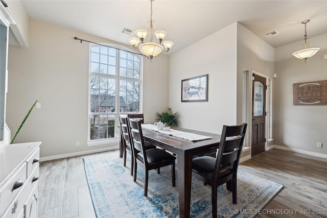 dining area with a notable chandelier and light wood-type flooring