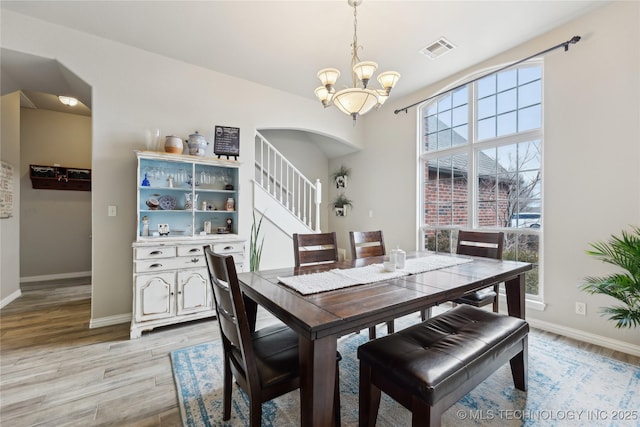 dining space with a chandelier and light hardwood / wood-style floors