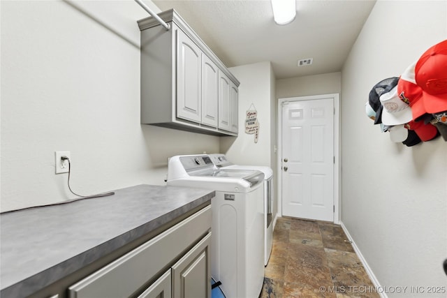 laundry room featuring cabinets and washer and dryer