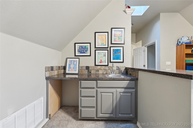 bathroom featuring lofted ceiling and sink