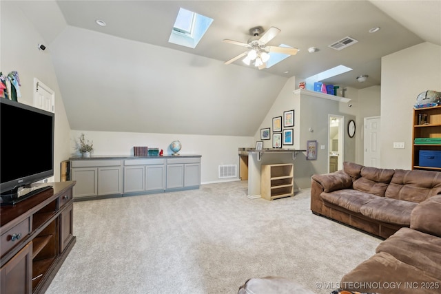 living room featuring lofted ceiling with skylight, light colored carpet, and ceiling fan