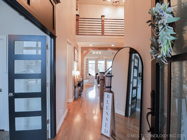 foyer featuring an inviting chandelier, hardwood / wood-style flooring, and a high ceiling