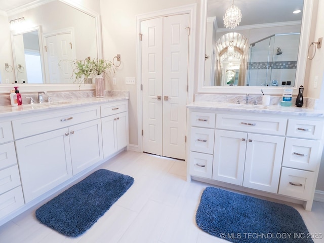 bathroom with crown molding, vanity, a shower with shower door, and an inviting chandelier