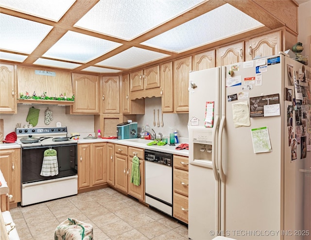 kitchen with sink, light brown cabinetry, and white appliances