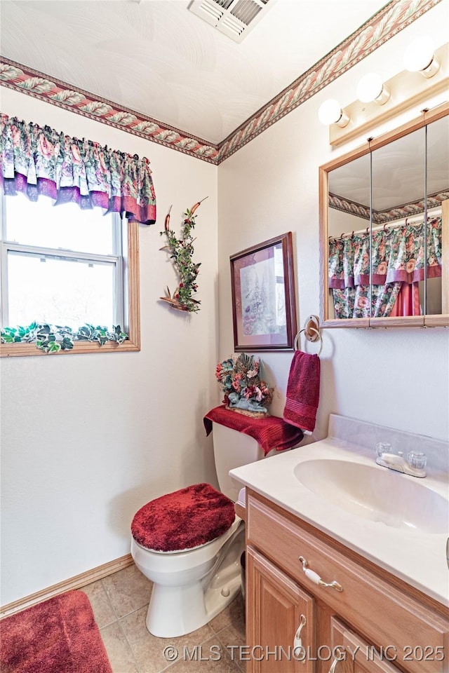 bathroom featuring tile patterned flooring, vanity, and toilet