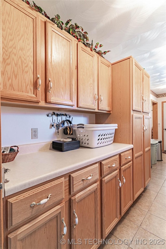 kitchen featuring light tile patterned floors and light brown cabinets