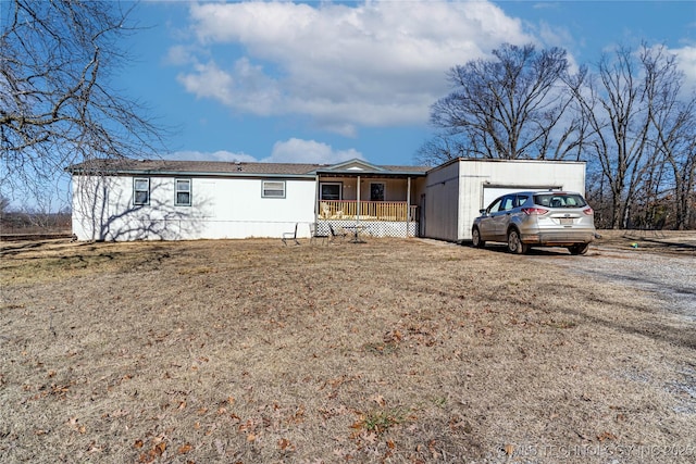 rear view of property with a porch and a yard