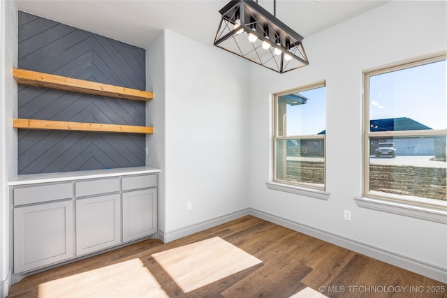 unfurnished dining area with a notable chandelier and light wood-type flooring