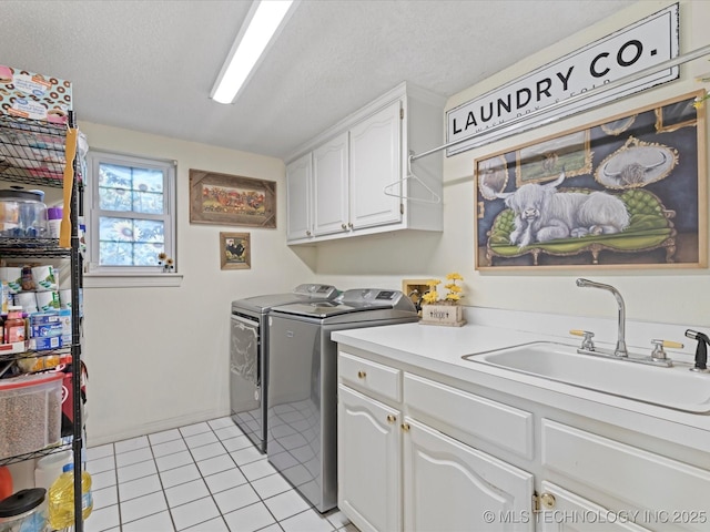 washroom featuring light tile patterned floors, sink, cabinets, independent washer and dryer, and a textured ceiling