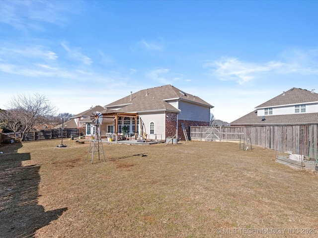 back of property with a yard and a patio area