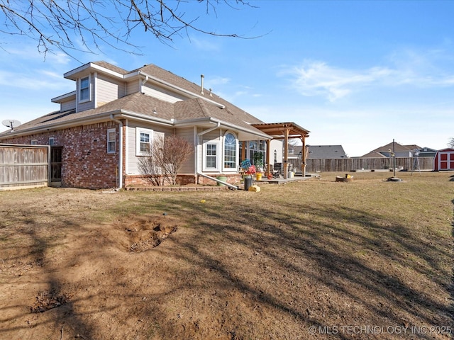 back of house featuring a pergola, a patio area, and a lawn