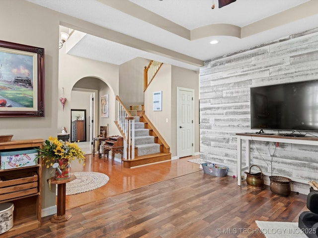 foyer entrance featuring hardwood / wood-style floors, ceiling fan, and wood walls