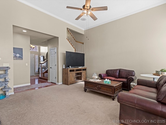 living room with carpet floors, ornamental molding, and ceiling fan