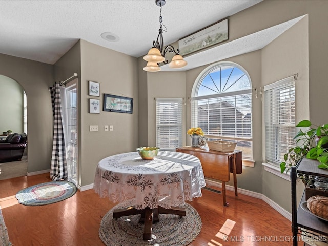 dining room featuring an inviting chandelier, hardwood / wood-style floors, and a textured ceiling