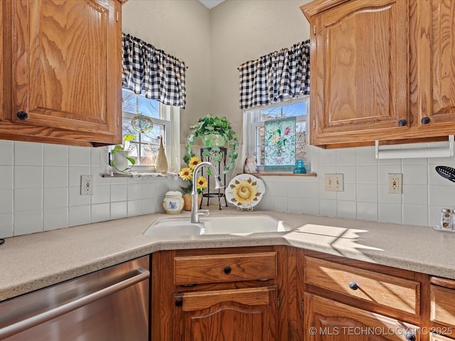 kitchen with dishwasher, sink, backsplash, and a healthy amount of sunlight