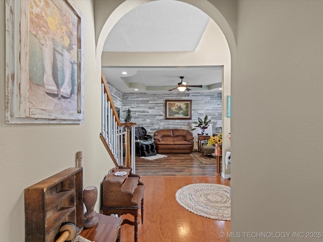 corridor with hardwood / wood-style floors and wood walls