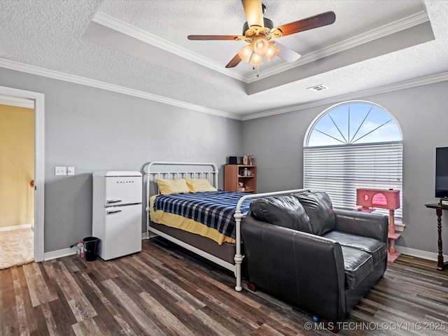 bedroom with ceiling fan, ornamental molding, and a tray ceiling