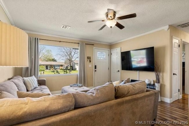 living room featuring ceiling fan, crown molding, wood-type flooring, and a textured ceiling