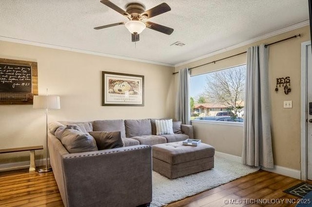 living room featuring hardwood / wood-style flooring, ornamental molding, and a textured ceiling