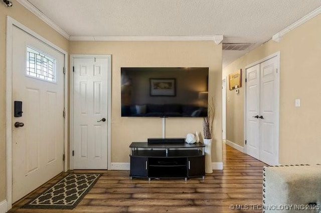 entrance foyer with crown molding, dark wood-type flooring, and a textured ceiling