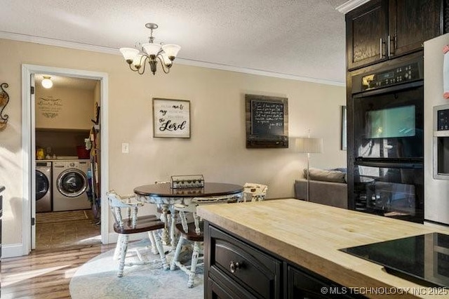 kitchen featuring pendant lighting, ornamental molding, washing machine and clothes dryer, dark brown cabinetry, and a textured ceiling