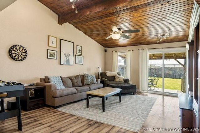 living room featuring lofted ceiling with beams, ceiling fan, light wood-type flooring, and wooden ceiling