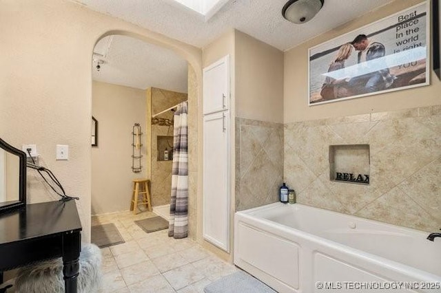 bathroom with separate shower and tub, tile patterned floors, a textured ceiling, and a skylight