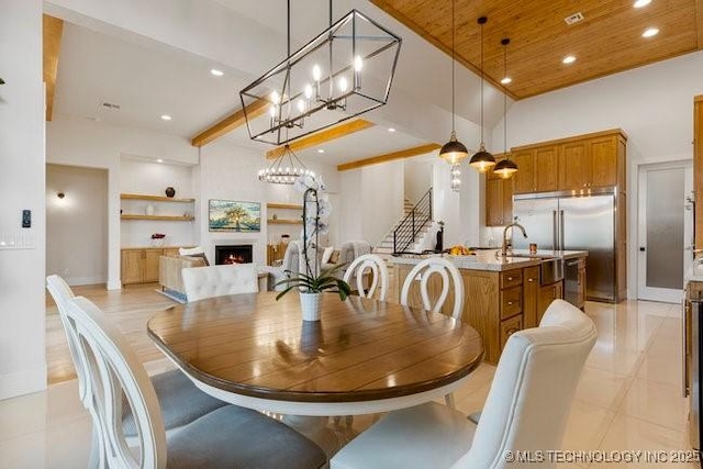 tiled dining room featuring a notable chandelier, wood ceiling, sink, and a high ceiling