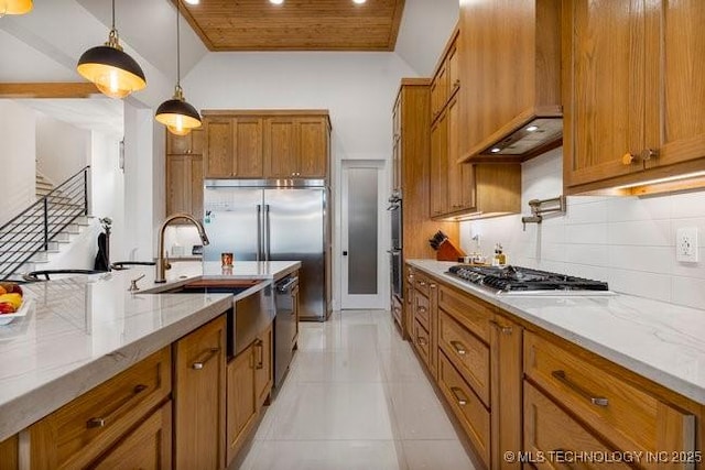 kitchen featuring premium range hood, sink, stainless steel gas cooktop, hanging light fixtures, and dishwasher