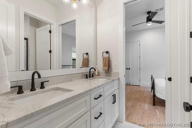 bathroom with hardwood / wood-style flooring, ceiling fan, and vanity