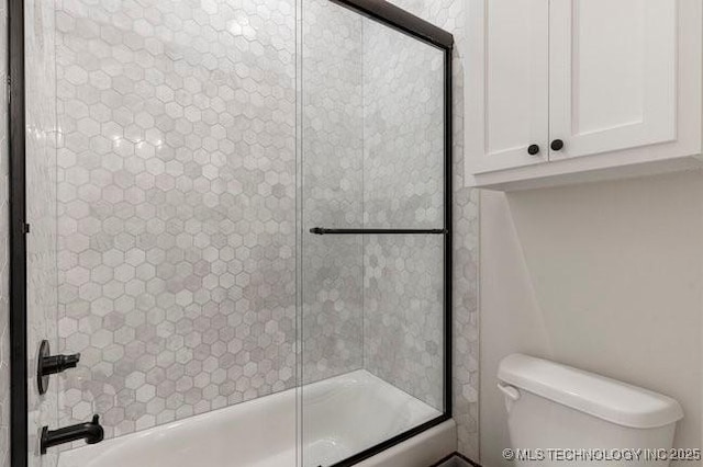 bathroom featuring shower / bath combination with glass door and toilet