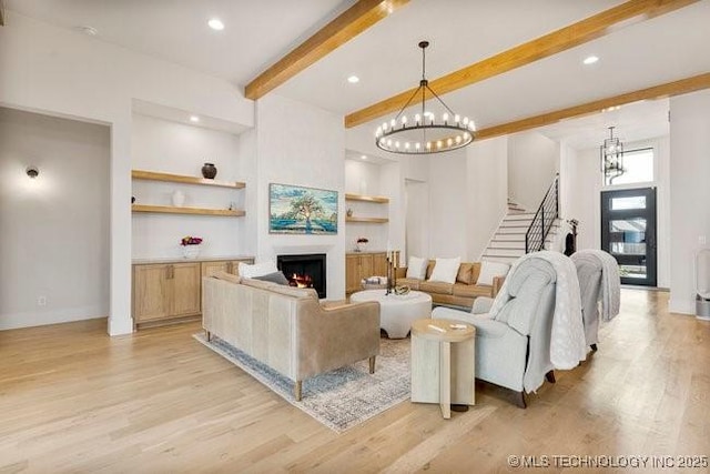 living room featuring an inviting chandelier, beam ceiling, light hardwood / wood-style flooring, and built in features