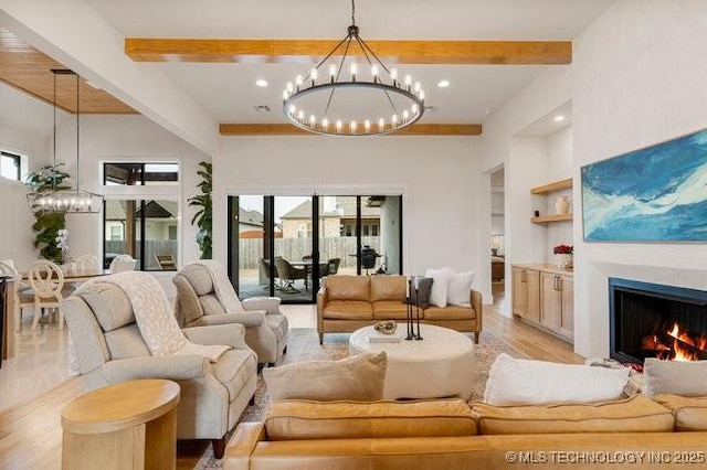 living room featuring an inviting chandelier, built in shelves, light hardwood / wood-style floors, and beamed ceiling