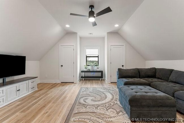 living room with ceiling fan, lofted ceiling, and light wood-type flooring