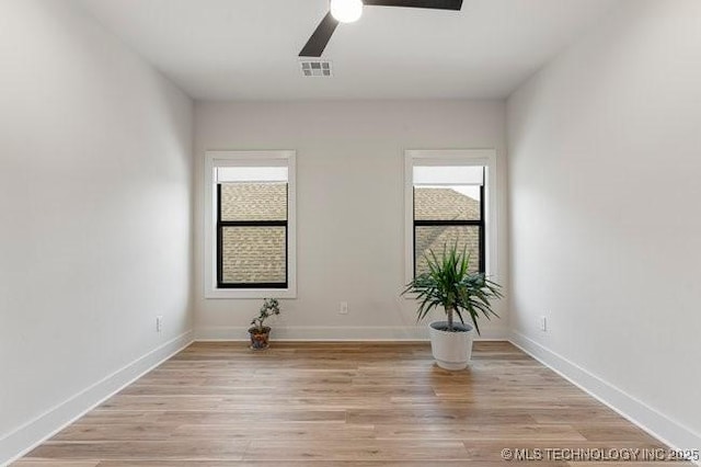 unfurnished room featuring ceiling fan, light wood-type flooring, and a wealth of natural light