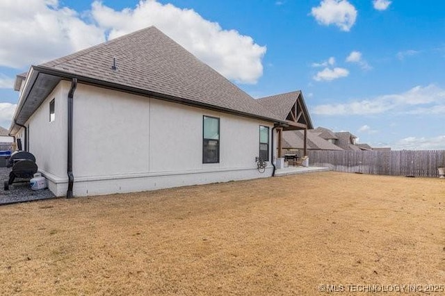 view of side of home with a yard