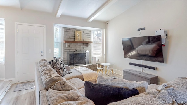 living room featuring beamed ceiling, wood-type flooring, and a fireplace