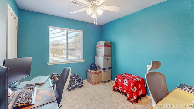 carpeted office space featuring ceiling fan