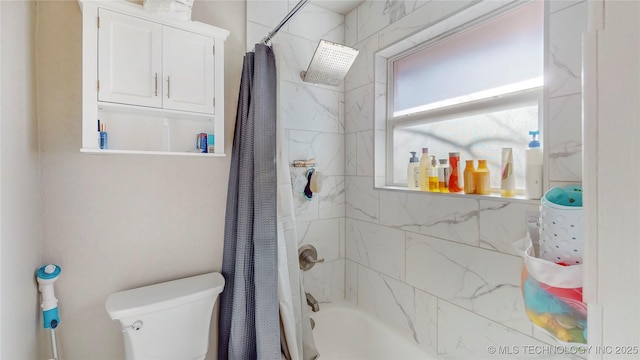 bathroom featuring shower / tub combo and toilet