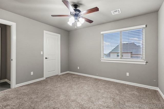 carpeted spare room featuring ceiling fan