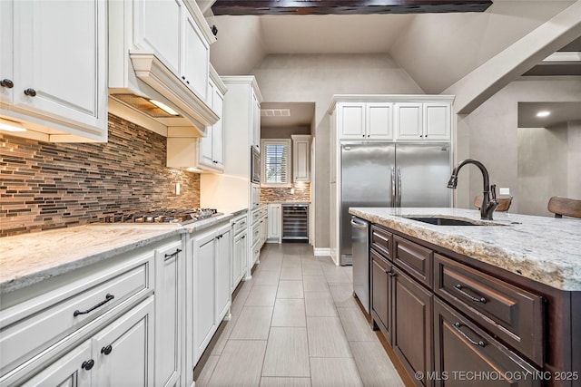 kitchen with white cabinetry, appliances with stainless steel finishes, dark brown cabinets, and sink