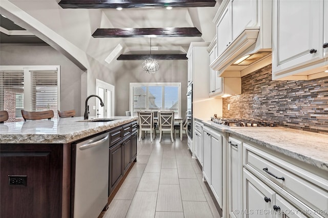 kitchen with sink, light stone counters, white cabinetry, appliances with stainless steel finishes, and backsplash